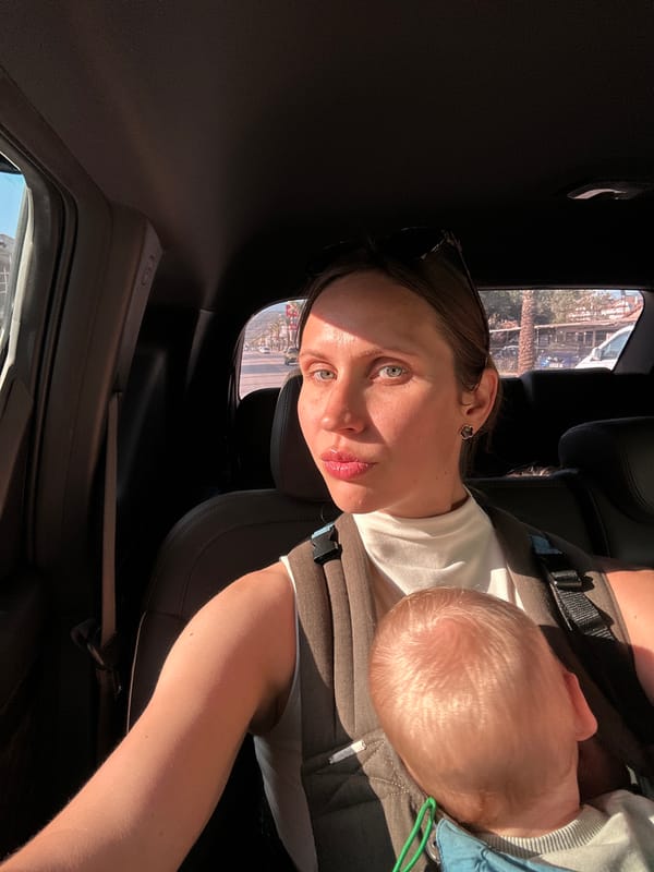 Woman drives with baby in chest carrier in Fethiye