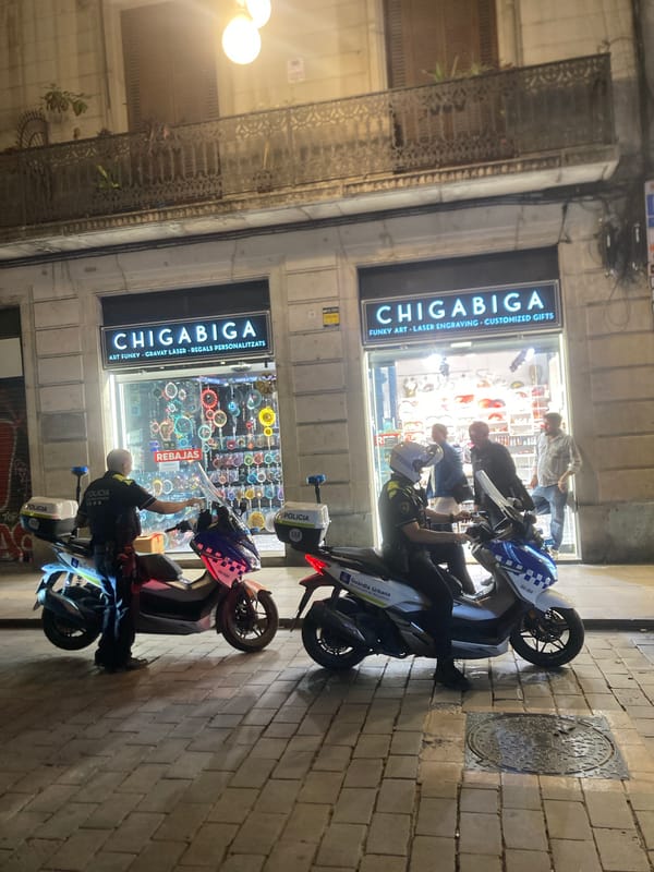 Police patrol outside Barcelona art shop on summer evening
