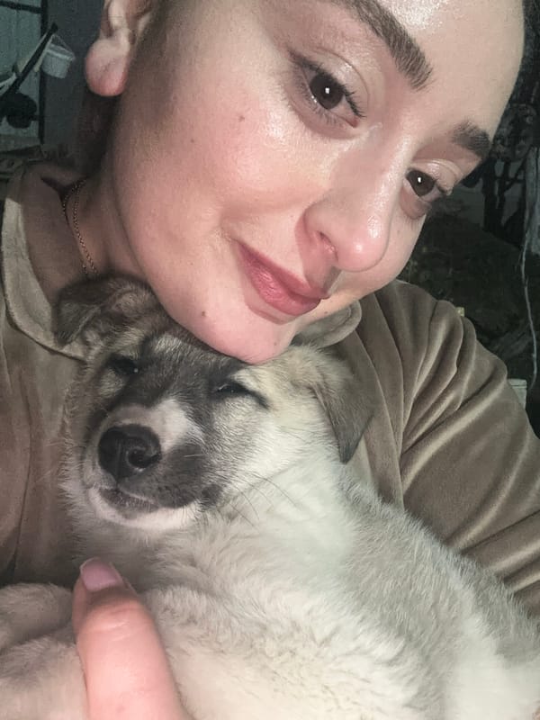 Woman tenderly holds puppy in affectionate moment in Georgia