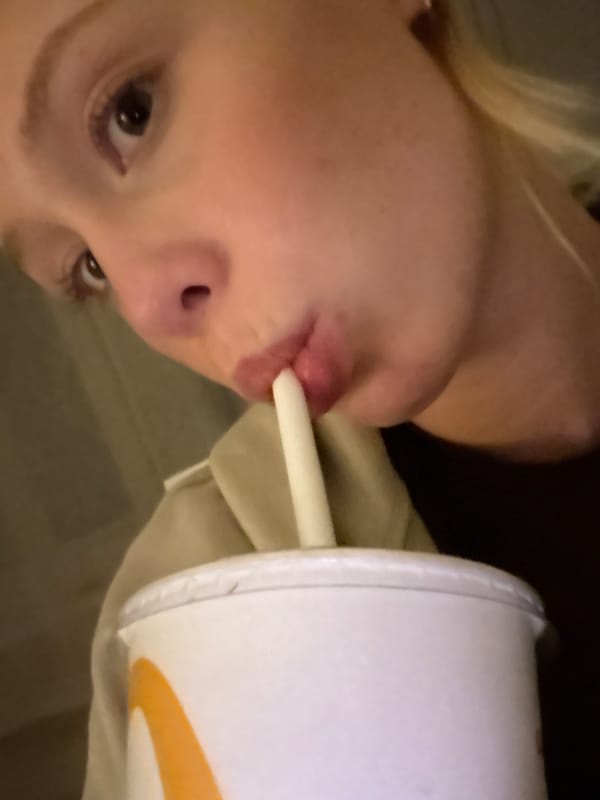 Person drinks from cup with straw in Tunbridge Wells