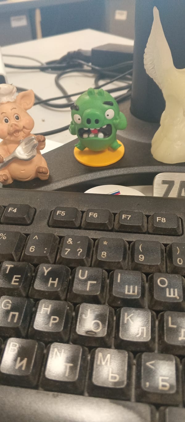 Cyrillic keyboard and desk trinkets hint at a Russian workspace