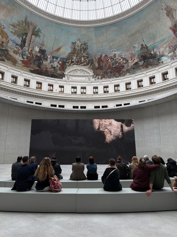 Visitors rest beneath ornate painted dome in Paris building