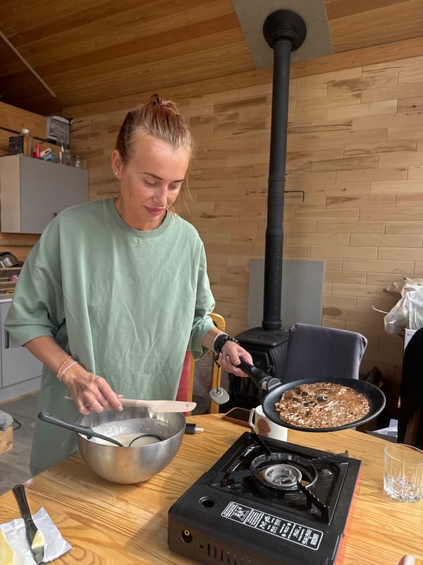 Woman cooks pancakes in early morning kitchen in Russia