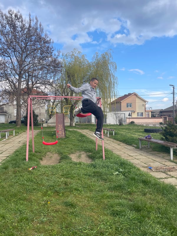 Young acrobat performs stunts on swing set in Bulgarian park