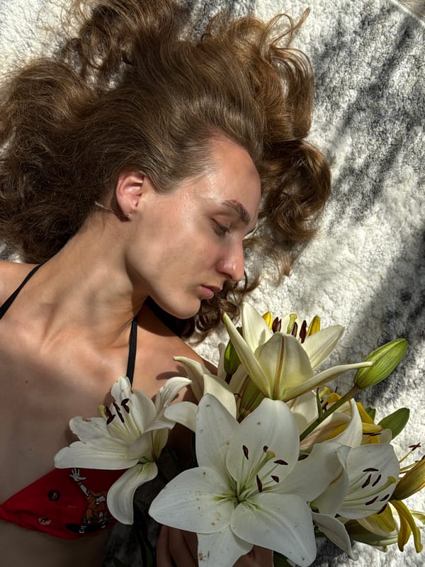 Sunlit rug scene with lilies and a side of fresh fruit