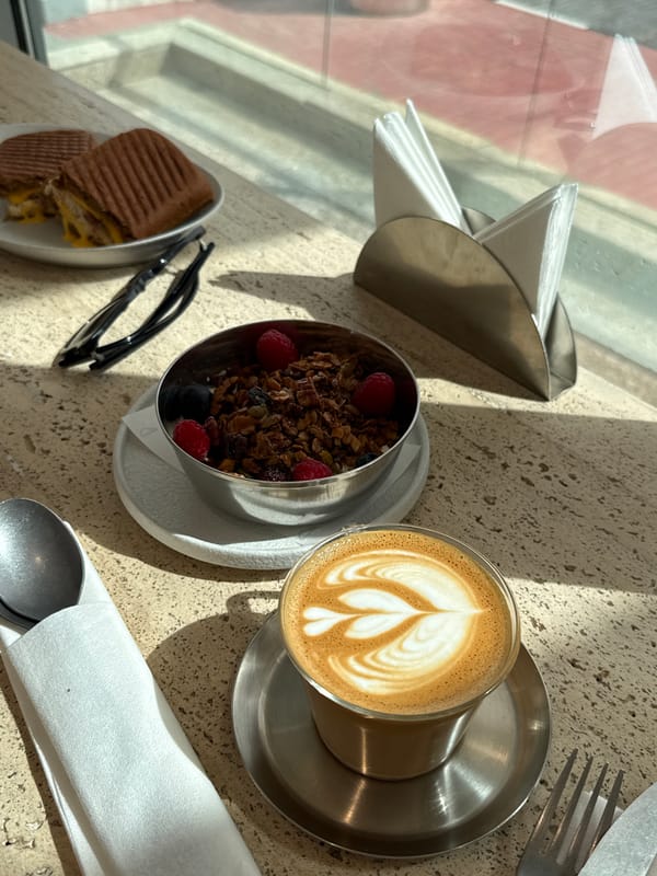 Morning cafe scene captured in Doha with latte and handbag