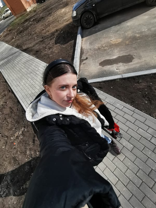 Woman takes selfies outdoors during sunny midday photo session