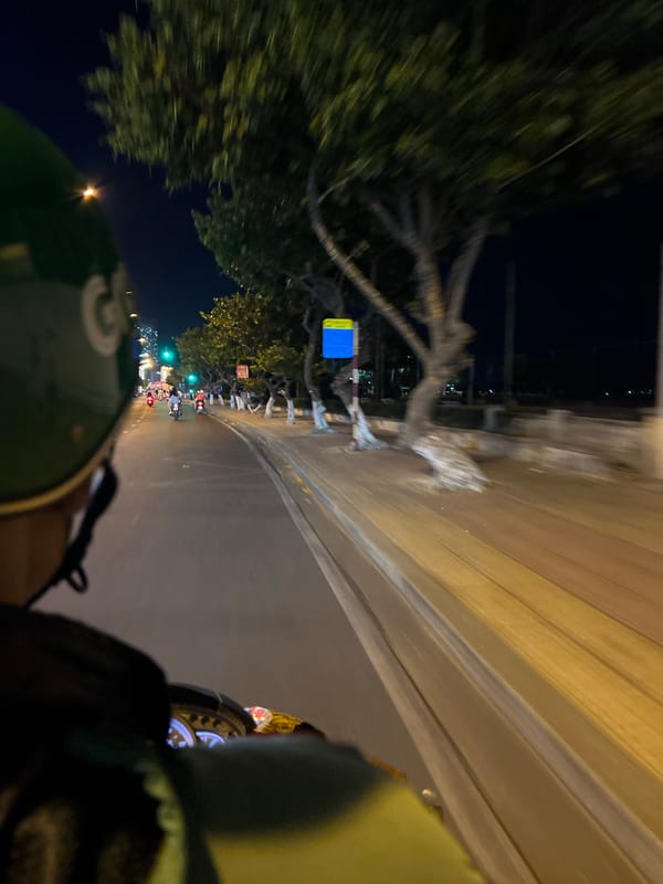 Nighttime traffic flows through illuminated Nha Trang streets