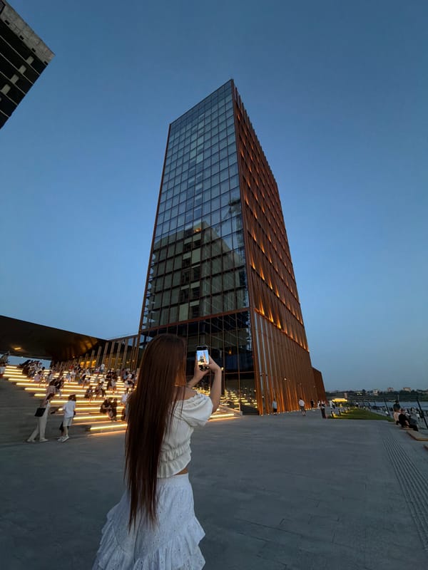 Woman photographs modern building in Kazan public square