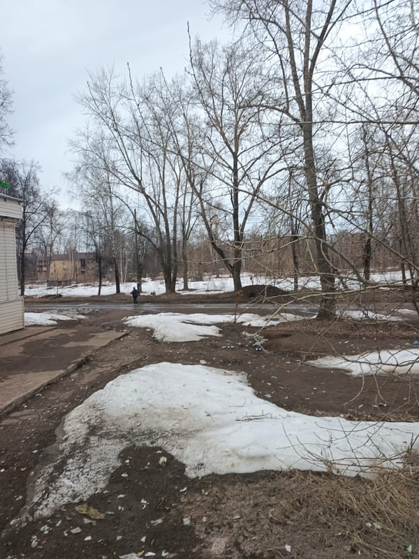 Person crosses road in early spring Chaikovsky, Russia