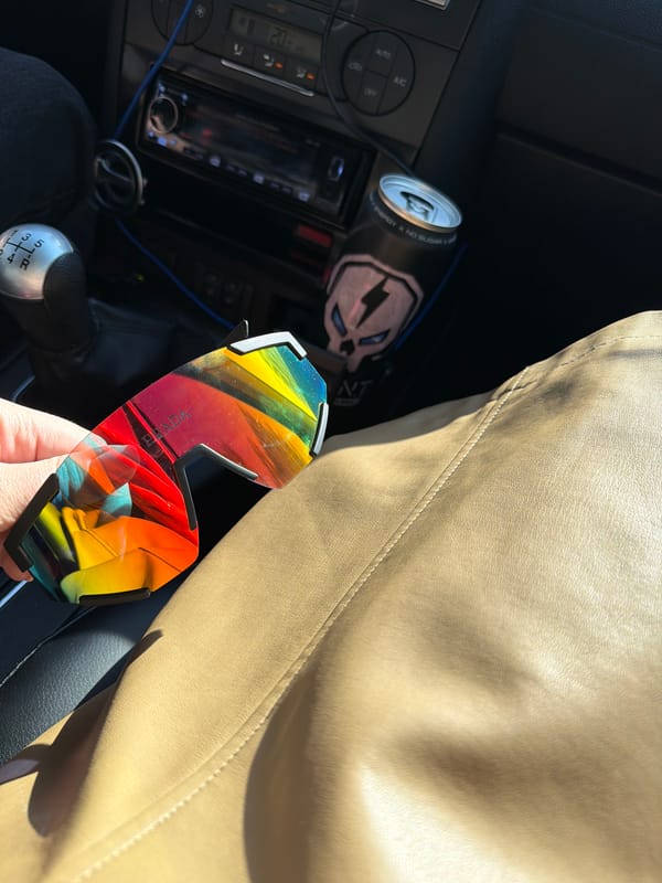 Person displays Prada sunglasses in car interior in Russia
