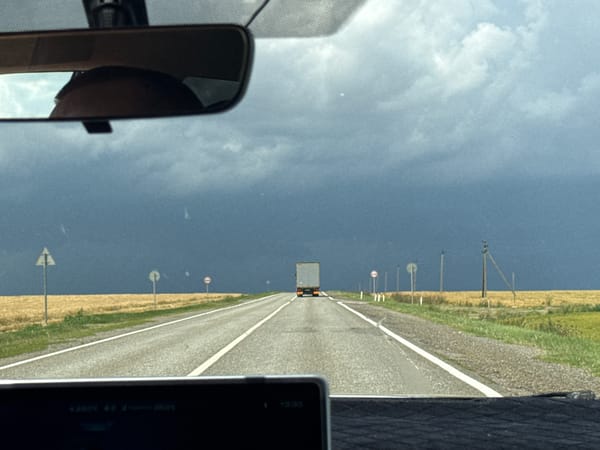 Road trip through Svetlograd farmland under dramatic summer skies