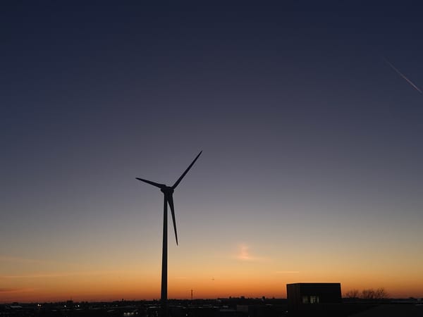 Wind turbine silhouetted against sunrise in Maasdijk, Netherlands