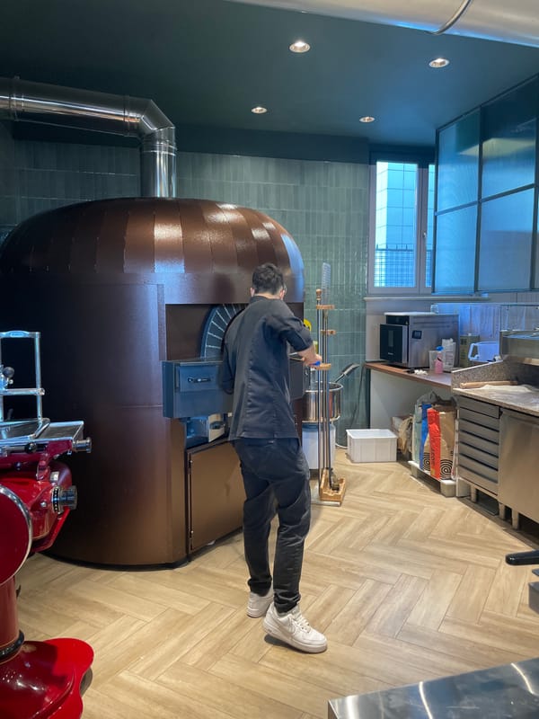 Pizza maker works traditional oven in Busto Arsizio restaurant
