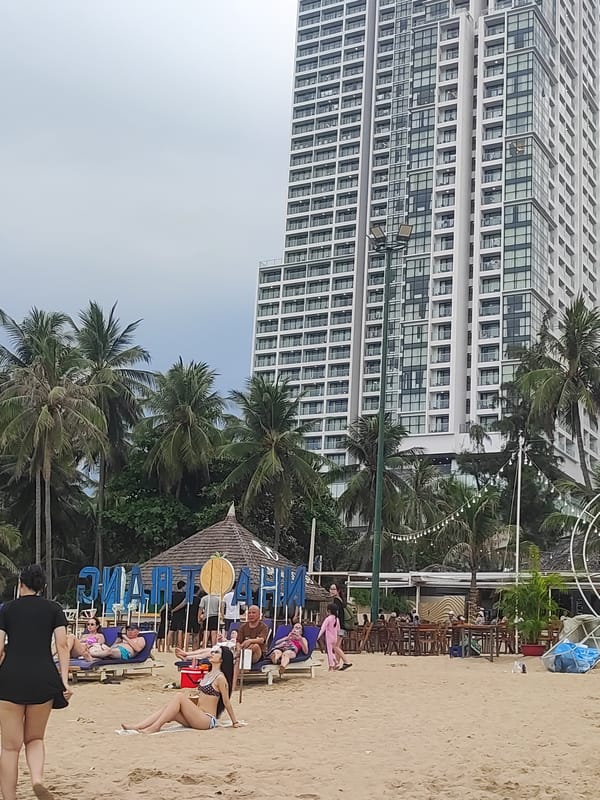 Busy morning at Nha Trang beach under overcast skies