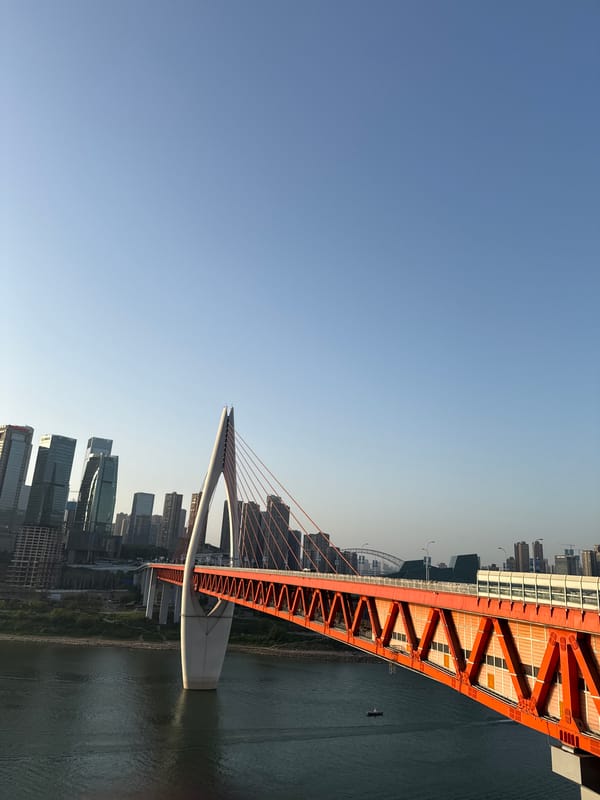 Tourists pose with statues near Chongqing's Hongyadong Bridge