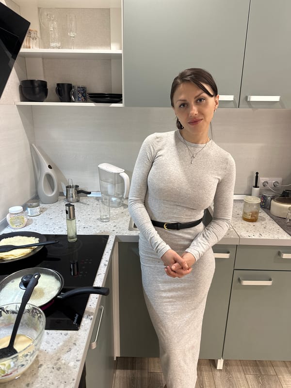 Woman cooks pancakes in kitchen, Murino Russia evening