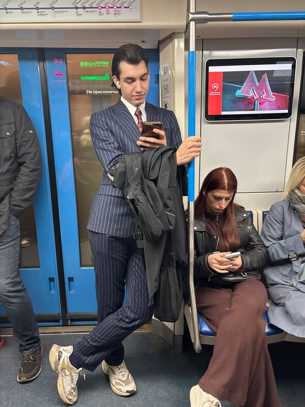 Moscow commuter checks phone during subway ride