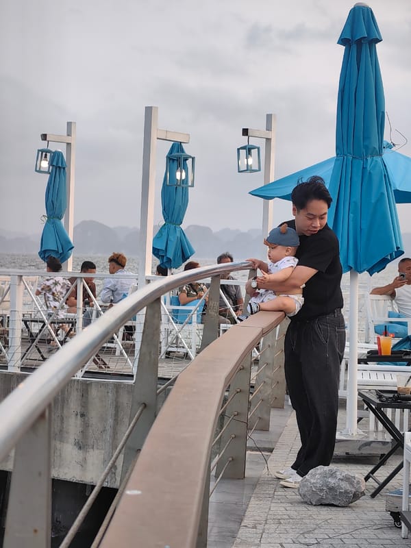 Man with baby visits waterfront cafe in Vietnam