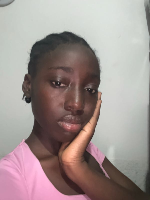Woman photographs herself in bedroom with purple headboard, Abuja