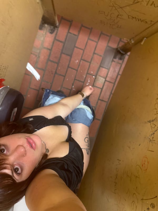 Late-night selfie captured in graffitied Athens restroom