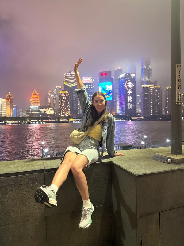 Woman poses against Shanghai skyline backdrop in nighttime photo