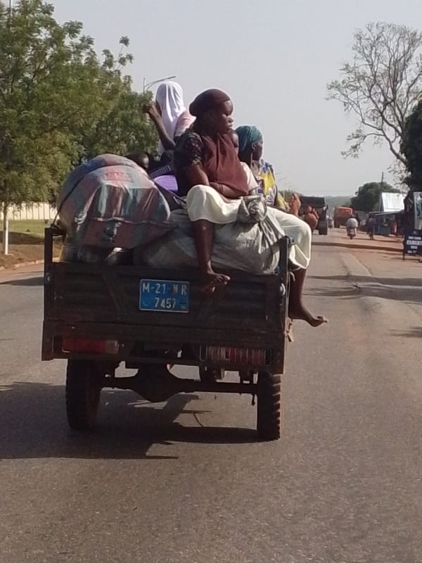 Passengers ride in truck bed with cargo in Ghana