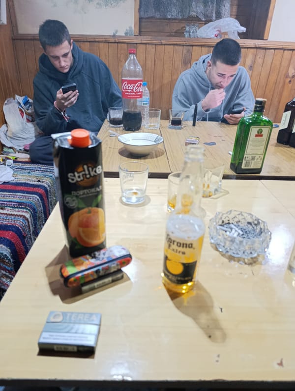 Two men check phones while drinking in Silistra