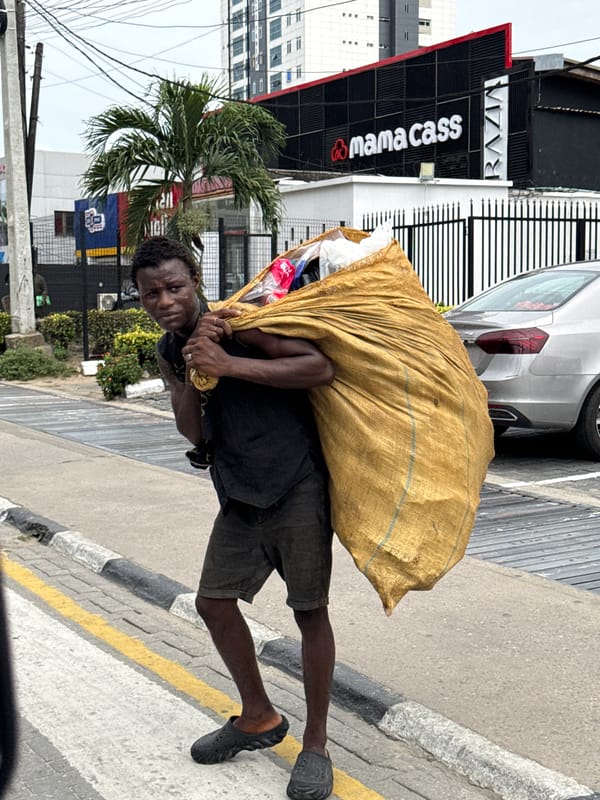Man with yellow bag walks past Mama Cass building