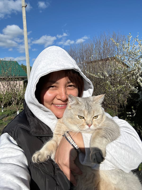 Woman poses with cat in Russian garden setting