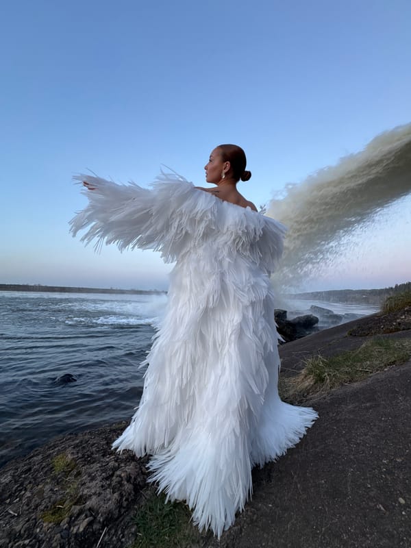 Woman in white feathered dress photographed at Noviy waterfall