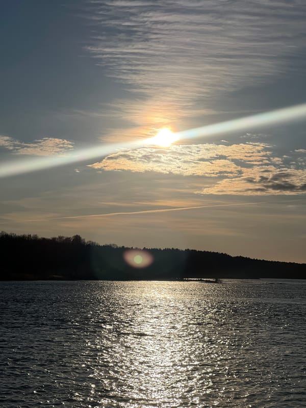 Dramatic sunset captured at Riga waterfront with boat and clouds
