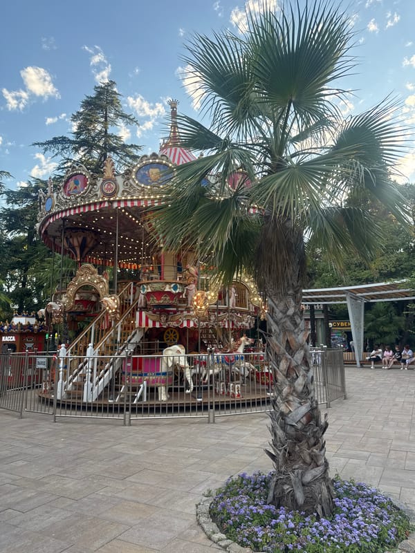 Carousel, snacks, and giant finger sculptures at a Sochi amusement area
