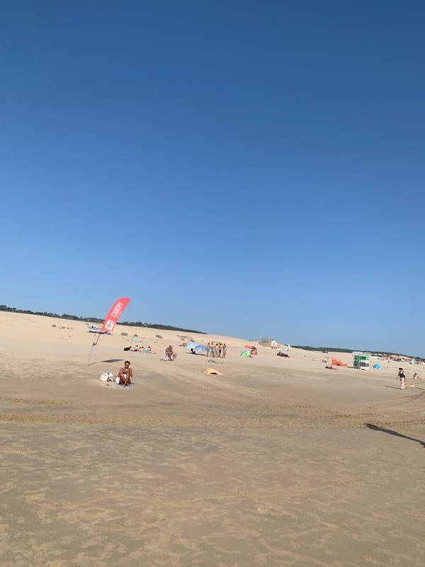 Red tractor on the sand at Costa da Caparica beach