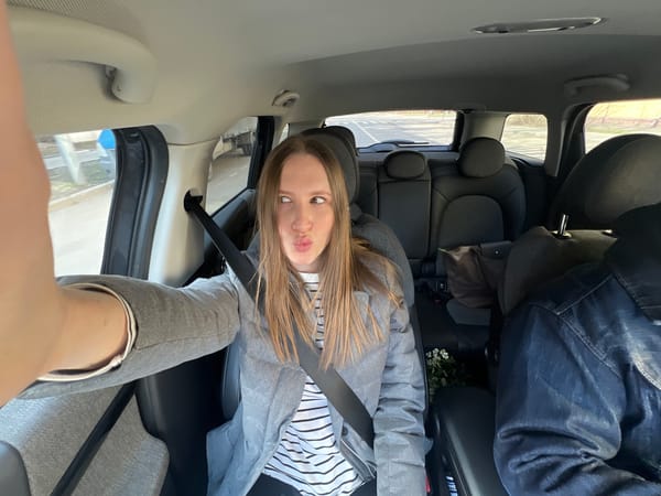 Woman in striped shirt drinks from cup in Moscow car