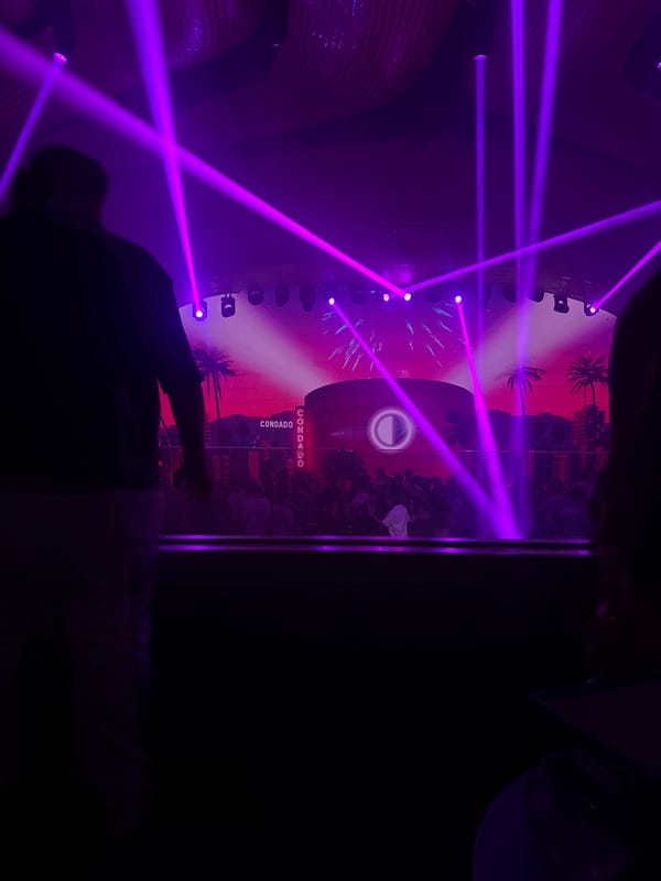 DJ set underway at a packed nightclub with laser lights