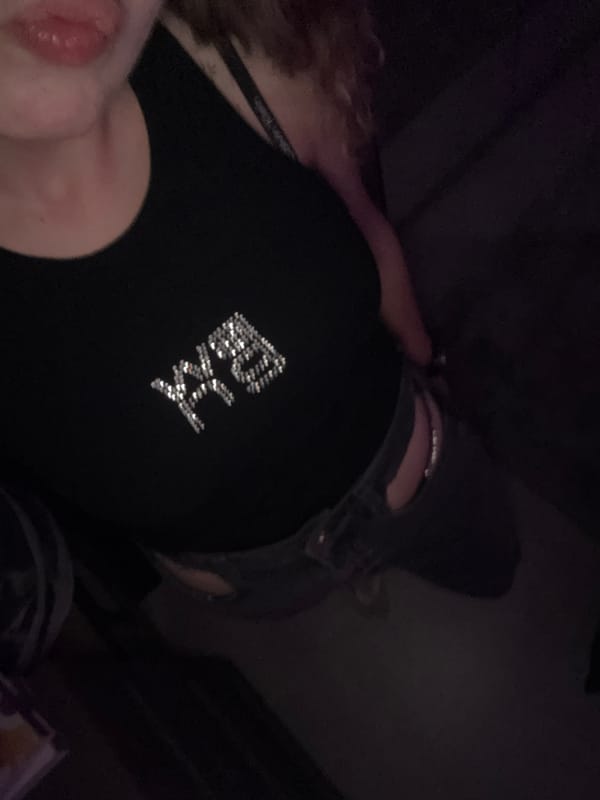 Person in rhinestone-embellished black top photographed indoors in Turin