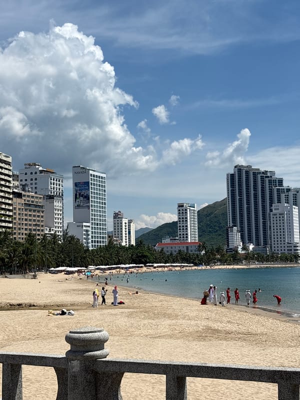 Busy day at Nha Trang beach, city skyline in the back