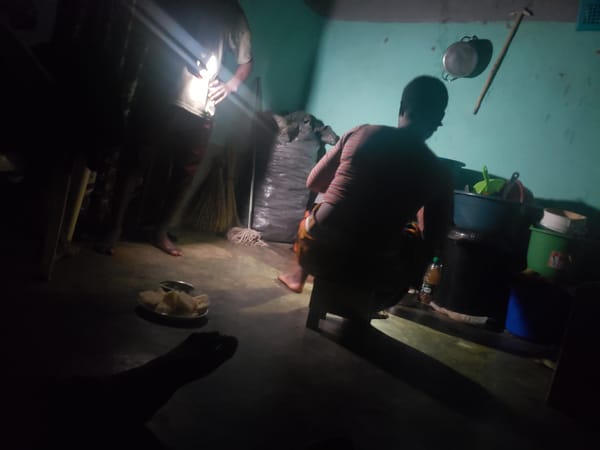 Person uses light source in dim room in Kachia