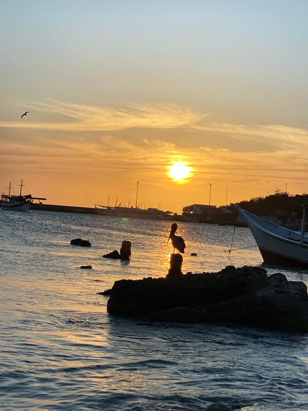 Sunset documented at Juan Griego harbor with fishing vessel