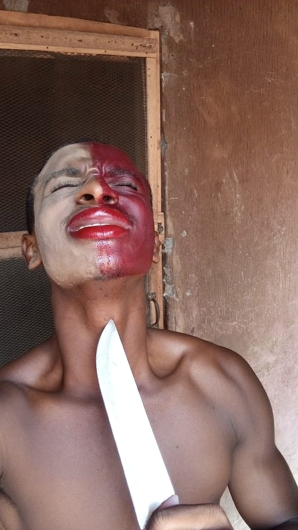 Person performs dramatic knife-to-throat act with split face paint