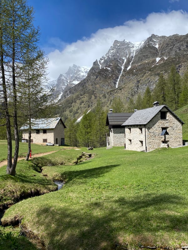 Hiker documents alpine scenery, trail markers in Baceno, Italy