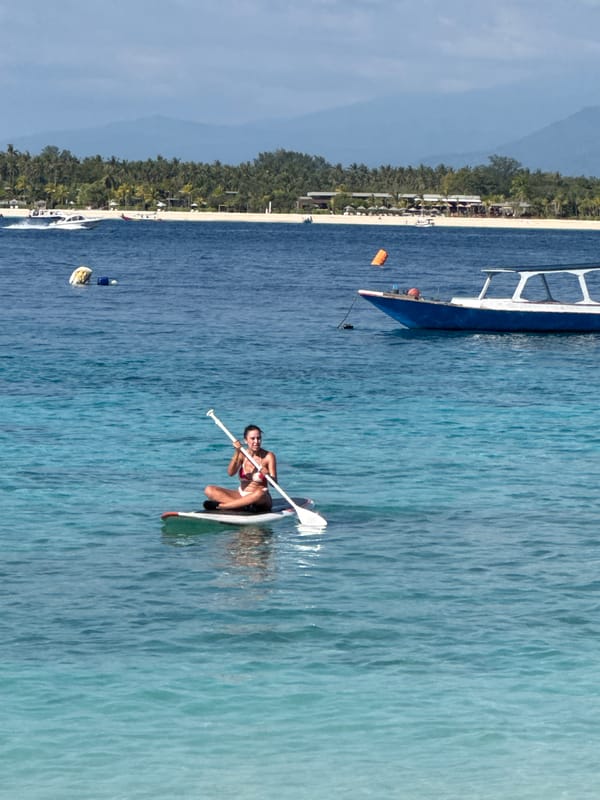 A laid-back Indonesian beach day with boats, snorkelers, and sun