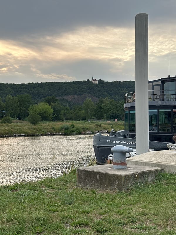 Cloudy afternoon along a riverside walkway with coffee in hand