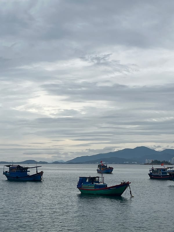 Fishing boats anchor in Nha Trang bay under cloudy skies