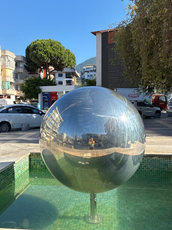 Pigeons and public art fill a sunny Alanya square