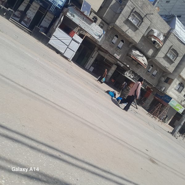 Daily life documented in Nuseirat streets, smoke visible