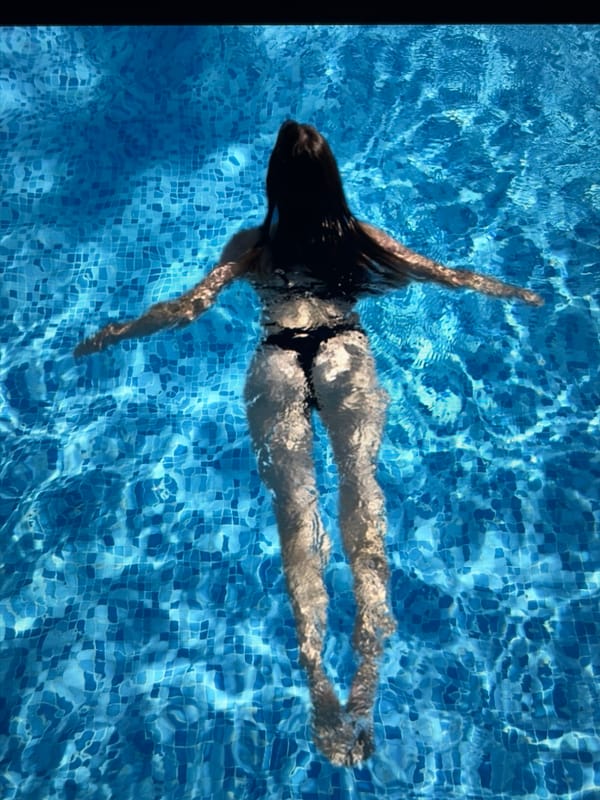 Floating on back in a blue tiled swimming pool