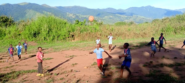 Children play ball on dirt field in Ngalula