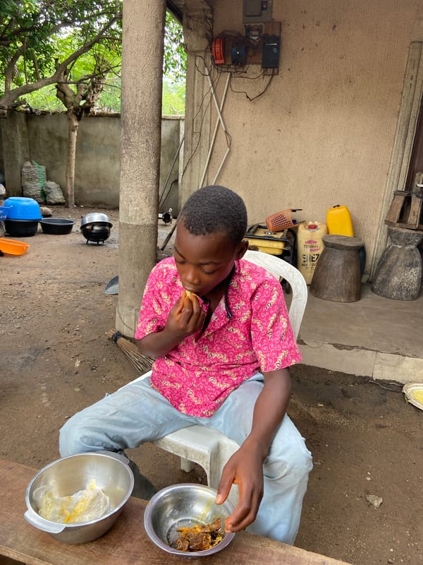 Young person eats outdoor meal in Mararaba, Nigeria